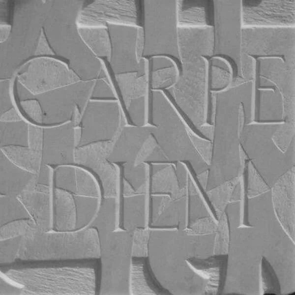 Image de la page contact représentant une gravure sur pierre 'Carpe Diem'